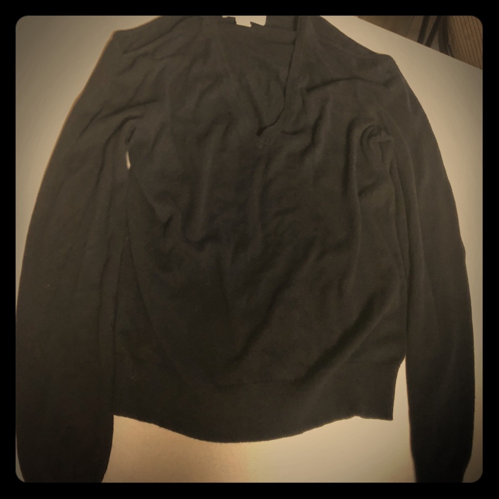Black Michael Kors open shoulder V-neck sweater.